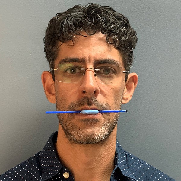 A man holding a blue stick in his mouth received a dental removal service in the Bahamas, US